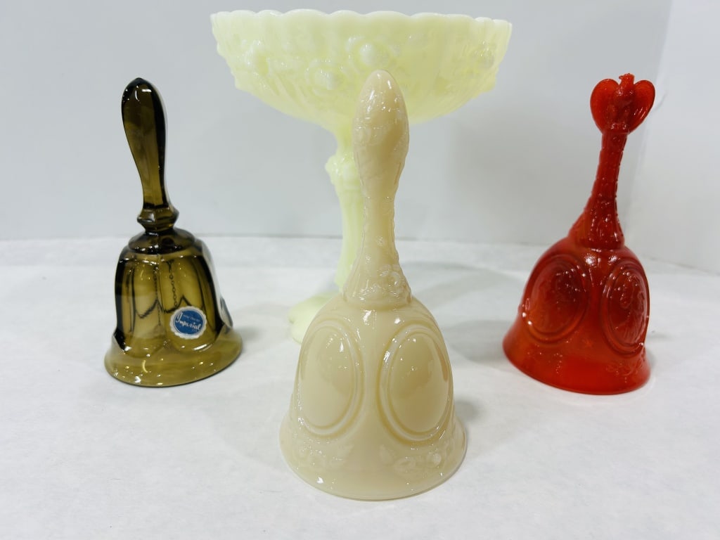 A Collection of Vintage Decorative Glass Including Imperial Amber Bell and Uranium Custard Comport: This collection consists of several vintage decorative glass objects including a pedestal comport and multiple hand bells. The pedestal comport is crafted from opaque custard yellow glass and demonstr