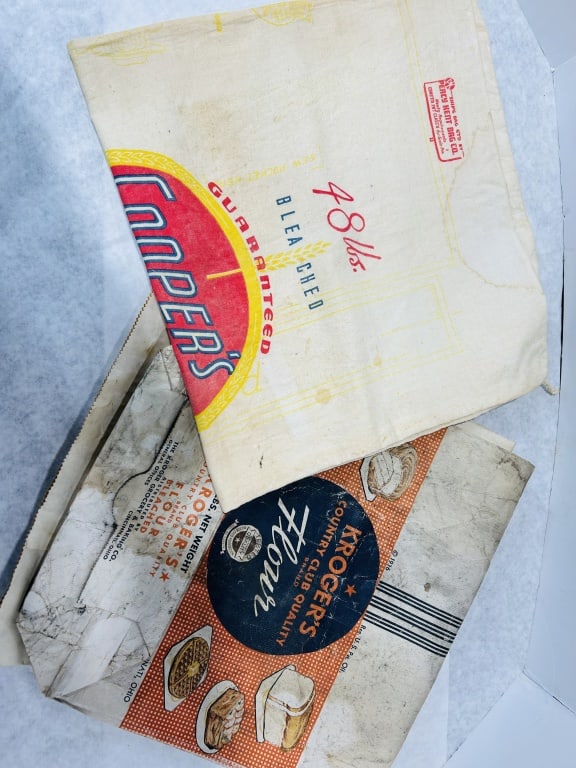 Two Vintage Mid-20th Century Advertising Flour Sacks: This lot features two original mid-20th century advertising containers for flour, representing different styles of period packaging. The first item is a cotton cloth sack for Coopers Bleached Flour wi