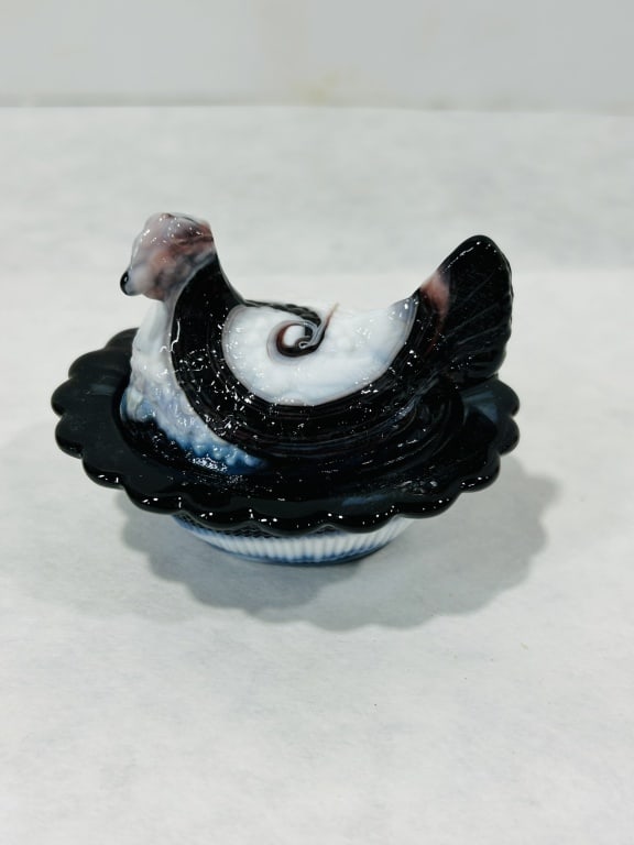 American Purple Slag Glass Hen on Nest Covered Dish: Attributed to Mosser Glass, this two-piece decorative covered dish is designed in the traditional hen on nest form. The piece is crafted from purple slag glass, featuring marbled swirls of opaque whit