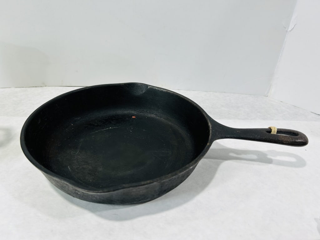 Wagner Ware Sidney -O- Cast Iron Skillet with Made in USA Mark: A vintage cast iron skillet produced by Wagner Ware of Sidney, Ohio. This piece features a circular body with two integrated pouring spouts and a single handle with an oval hanging hole. The underside