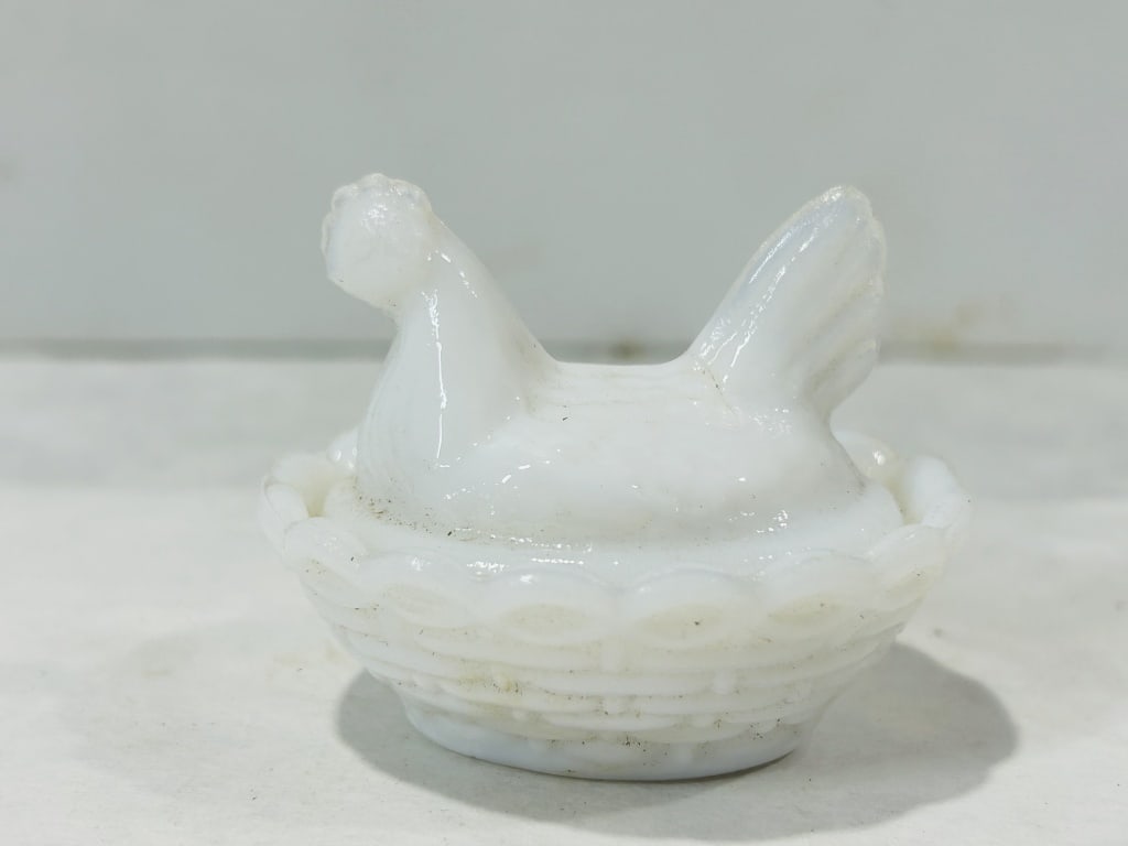 Miniature Milk Glass Hen on Nest Covered Dish: This miniature two-piece covered dish is fashioned from opaque white milk glass in the form of a hen on a nest. The design is attributed to Portieux Vallerysthal, featuring a top lid molded as a seate