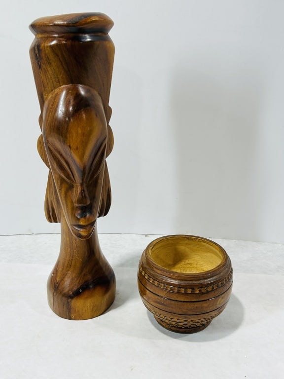 Two Hand Carved Wooden African Style Decorative Objects Including a Stylized Bust and a Patterned: This lot consists of two hand-carved hardwood decorative items executed in a stylized African aesthetic. The first object is an elongated bust featuring minimalist facial features including slit eyes,