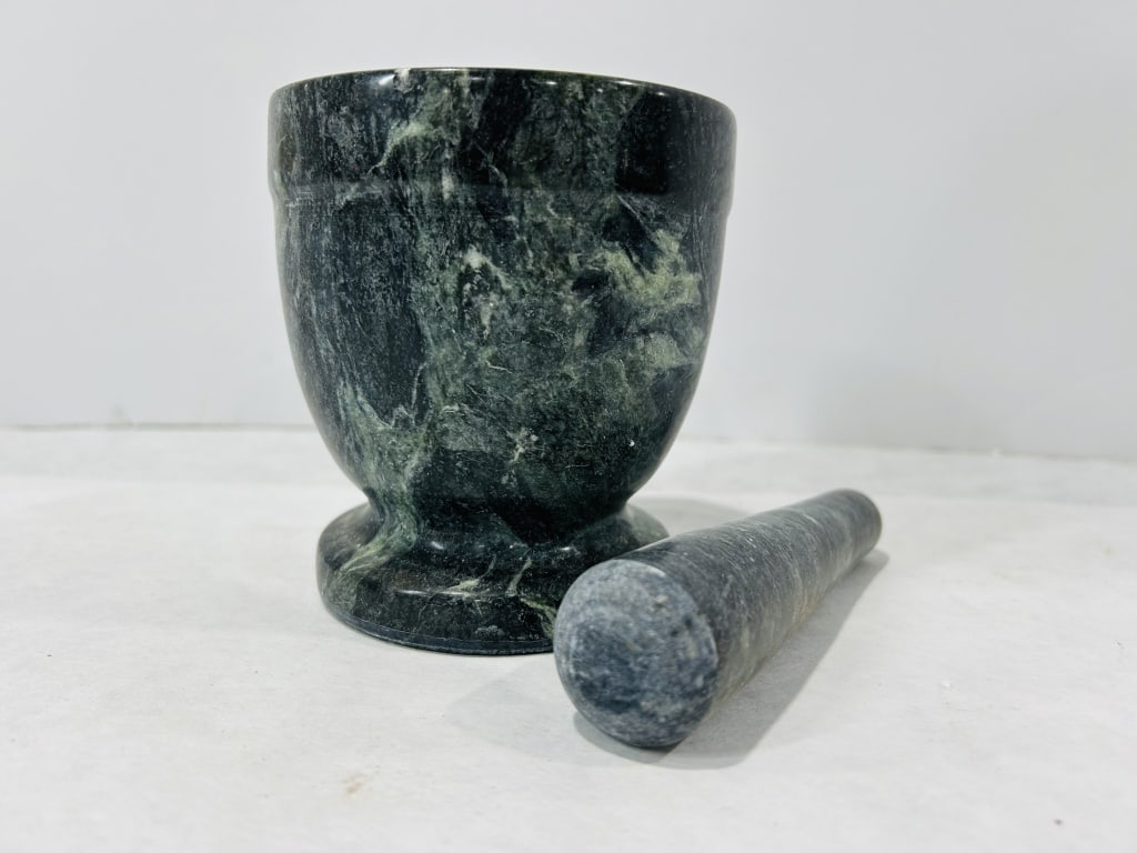 A Polished Green Marble Mortar and Pestle Set: Attributed to the manufacturer Fox Run, this two-piece set is crafted from carved and polished dark green marble with characteristic black veining. The mortar features a footed, chalice-style form