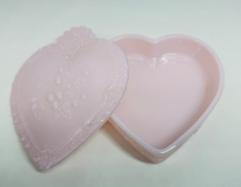 MOSSER PINK TUSCAN GLASS HEART BOX: A vintage heart-shaped trinket box executed in pink opalescent glass featuring relief-molded strawberry and foliate decoration. The piece is attributed to Mosser Glass and bears indistinct embossed ma