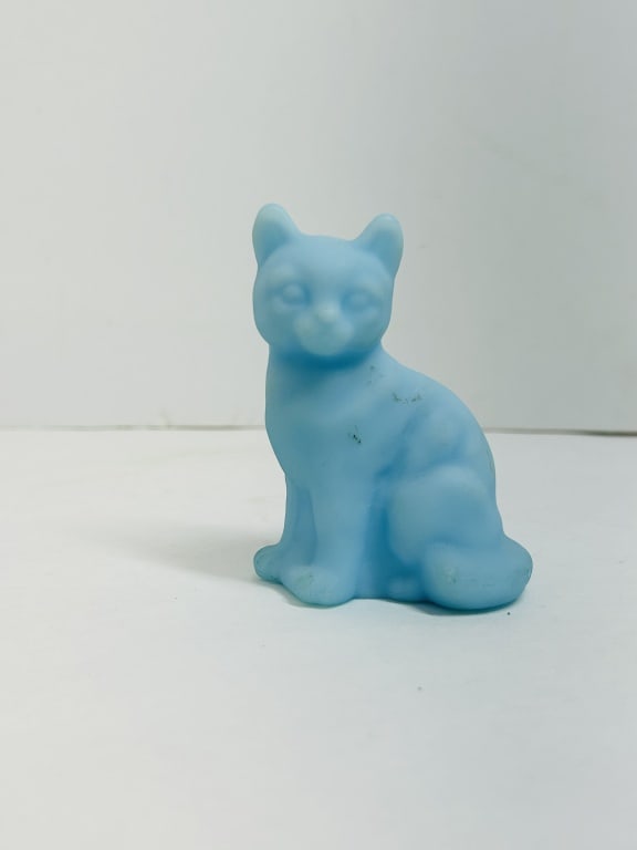 FENTON BLUE SATIN CAT: Seated cat figurine crafted from light blue satin glass with a frosted finish, attributed to the Fenton Art Glass Company. The piece features simplified molded details and internal air bubbles charact