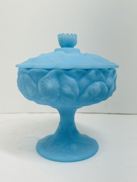 FENTON WATER LILY SATIN COMPOTE, 1980S: A Fenton Art Glass lidded footed compote in blue satin glass, featuring a molded high-relief Water Lily pattern with a scalloped rim and stylized finial. The underside of the base displays an embossed