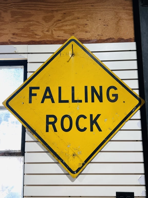 WV DOH METAL FALLING ROCK SIGN, 1987: A vintage West Virginia Department of Highways diamond-shaped metal road sign featuring black block lettering on a yellow reflective ground. The lower corner displays a stamped West Virginia state out