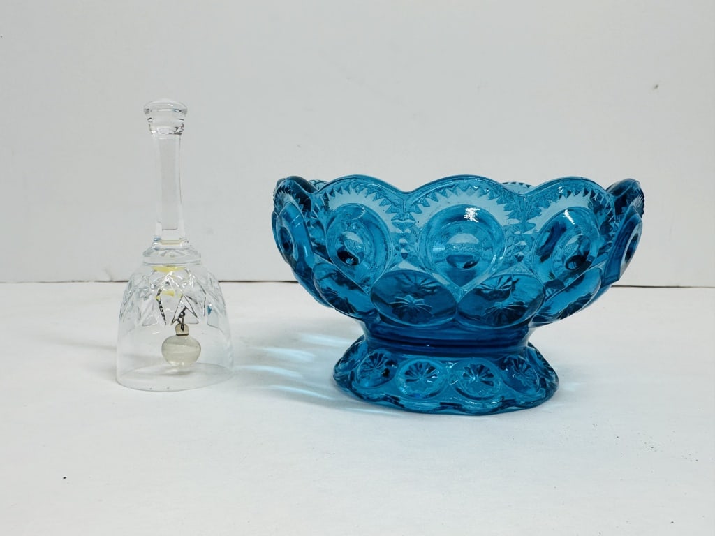 L.E. SMITH STYLE GLASS, MID-20TH CENTURY: A pressed blue glass footed bowl in the Moon and Star pattern, attributed to L.E. Smith, and a clear faceted glass table bell. No maker marks are present on either piece.
