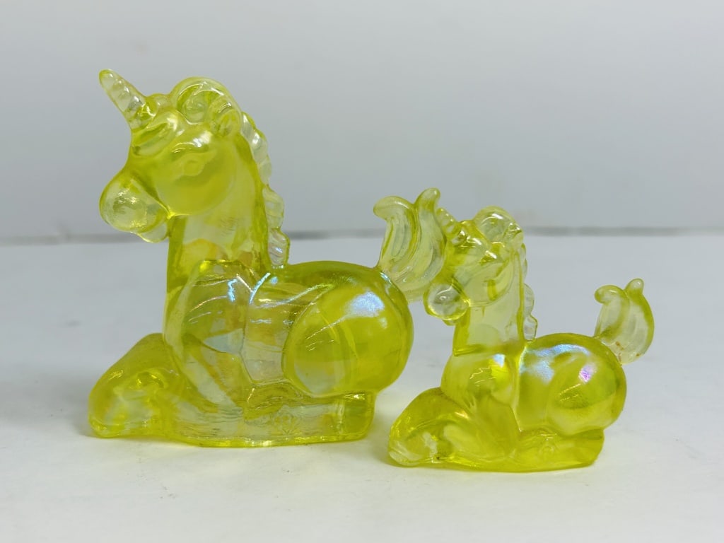 BOYD VASELINE GLASS UNICORN FIGURINES: A pair of iridescent citron art glass unicorn figurines produced by Boyd Art Glass. The larger specimen features the manufacturer's molded "B" in diamond trademark on the reverse.