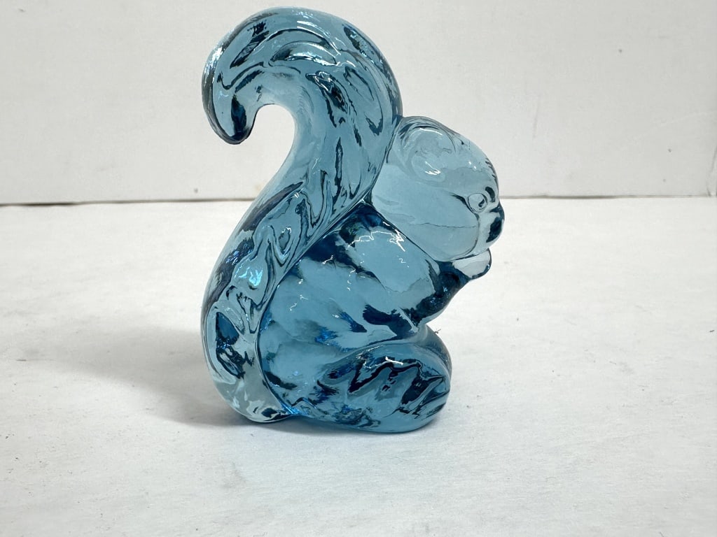 BOYD BLUE GLASS SQUIRREL, 1978-1983: A pressed turquoise blue glass figurine of a seated squirrel, known as Sammy the Squirrel, manufactured by Boyd?s Crystal Art Glass. An embossed mark featuring a stylized capital B within a diamond-sh