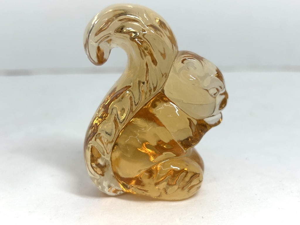 BOYD PEACH SQUIRREL FIGURINE: A stylized pressed glass figurine depicting a seated squirrel with a curled tail, executed in translucent amber glass. The piece is unsigned and displays a vertical mold seam.
