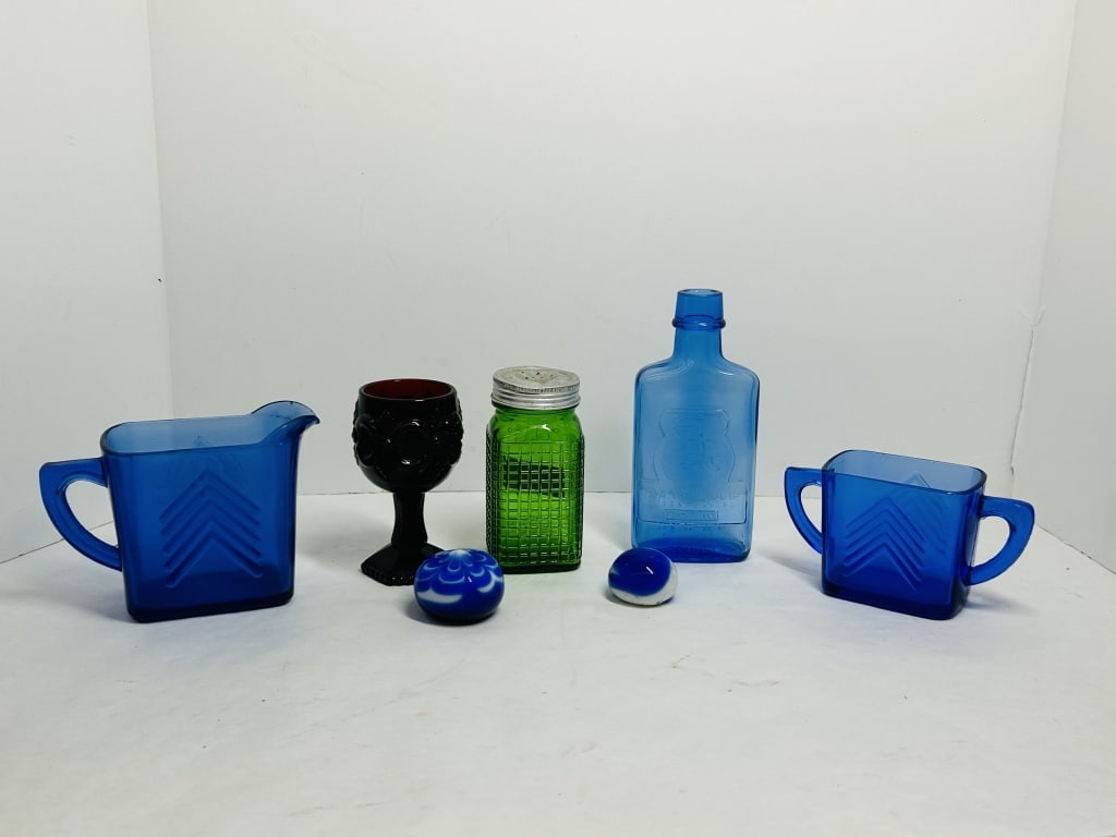 HAZEL-ATLAS AND VINTAGE GLASSWARE, 1930-1997: An assortment of 20th-century glassware including cobalt blue Chevron pattern items attributed to Hazel-Atlas and a Zanesville bicentennial commemorative bottle. The collection further features an eme