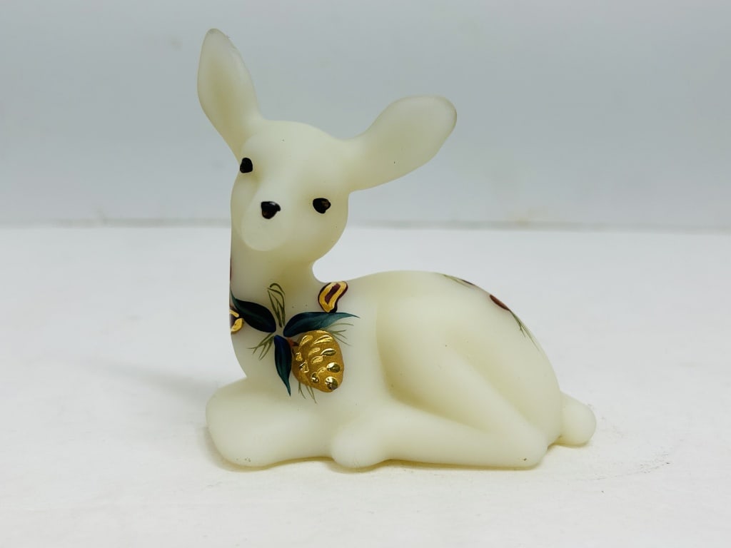 FENTON CUSTARD SATIN GLASS FAWN: Reclining fawn figurine produced by Fenton Art Glass Company in custard satin glass featuring hand-painted pinecone and needle decoration. The base is hand-signed by Fenton decorator Brenda Cumberledg