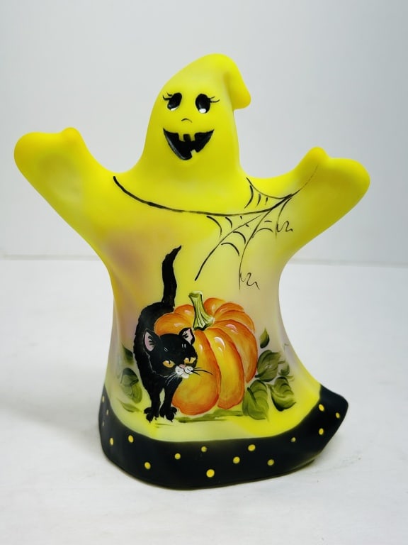 FENTON BURMESE GLASS GHOST, 2006: A limited edition Burmese glass ghost figurine produced by Fenton Art Glass and hand-painted by artist Michelle Kibbe with a black cat and pumpkin motif. The work is dated 2006, numbered 59/64, and be