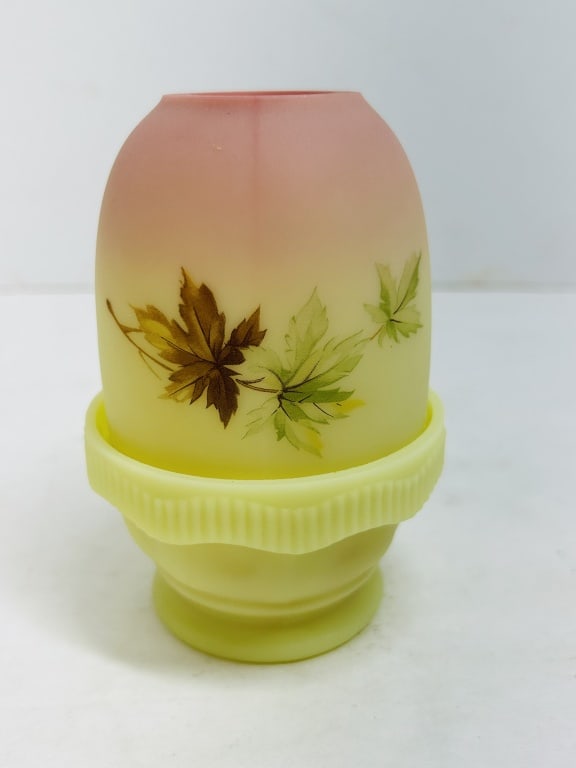 FENTON BURMESE FAIRY LAMP: Two-piece satin uranium glass fairy lamp featuring a peach-to-yellow gradient and hand-painted maple leaf decoration. The piece displays a characteristic bright green fluorescence under ultraviolet li