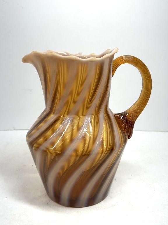FENTON AUTUMN GOLD OPALESCENT PITCHER: Vintage art glass pitcher attributed to Fenton in the Autumn Gold opalescent spiral pattern. The vessel features a ruffled rim and an applied ribbed amber glass handle with a crimped fan terminal.