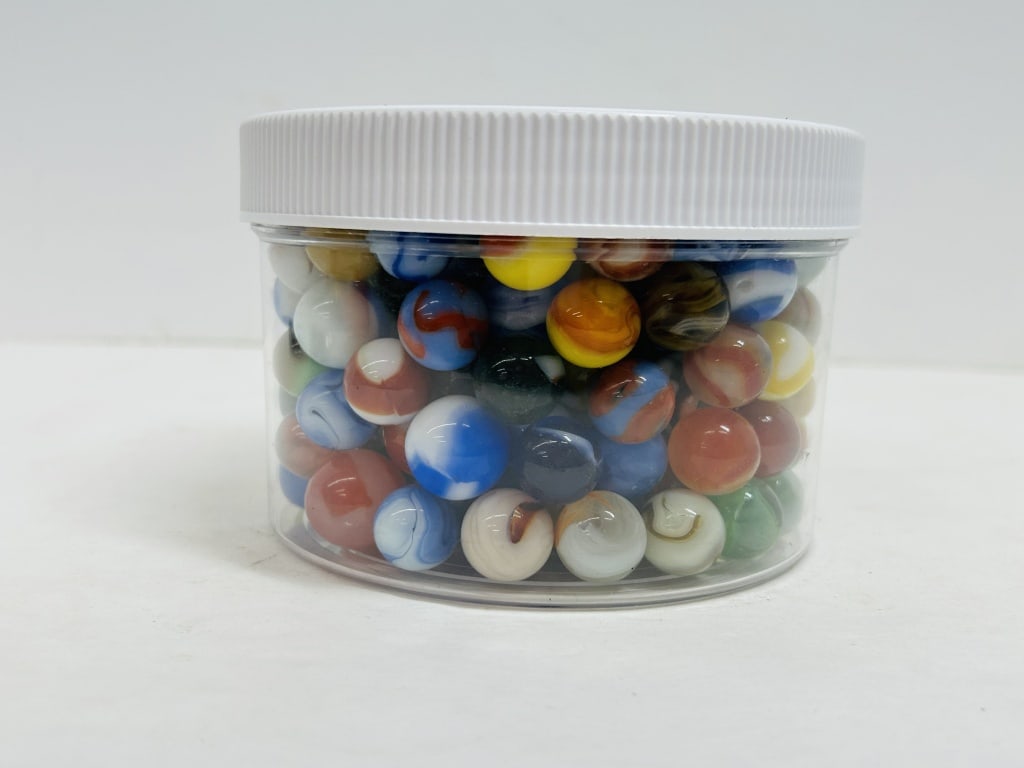 AMERICAN MIXED GLASS MARBLES VINTAGE: This collection consists of approximately 150?200 machine-made glass marbles featuring patches, swirls, and a large shooter. The lot includes several specimens of uranium glass that exhibit bright flu