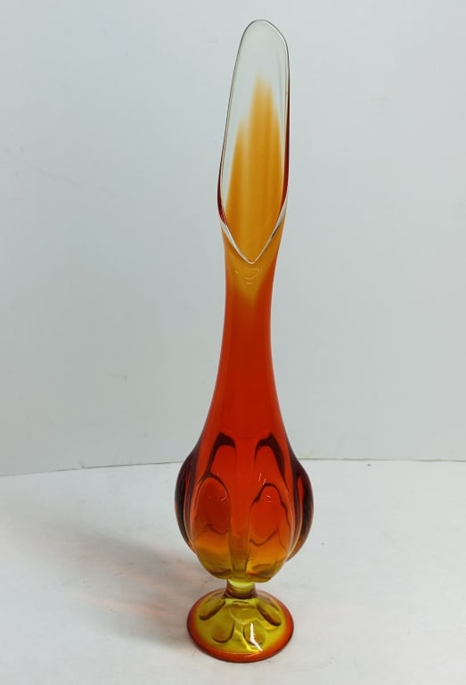 VIKING PERSIMMON GLASS SWUNG VASE, 1960S: Mid-Century Modern "Epic" line swung glass vase in the Persimmon colorway attributed to Viking Glass. The vessel features a molded six-petal pedestal base extending into an elongated neck with a hand-
