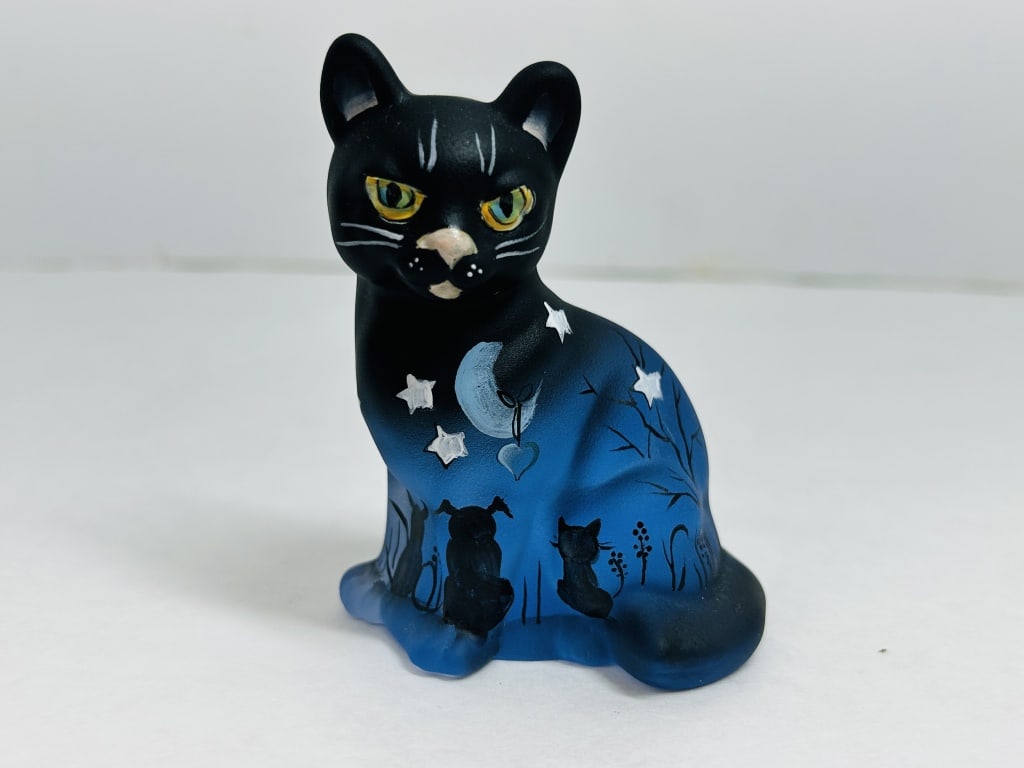KIM BARLEY SEATED CAT GLASS, 2024: Hand-painted frosted art glass figurine featuring a celestial motif executed by artist Kim Barley on a classic seated cat mold. The underside is signed by the artist and dated 2024, numbered 18 of a l