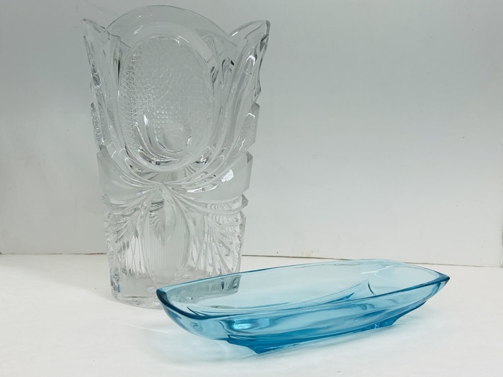 TWO CUT CRYSTAL AND GLASS VESSELS: This lot features a large lead crystal vase with deep strawberry diamond and fan cut patterns and a mid-century aqua blue pressed glass dish. The elongated blue vessel is attributed to the designs of 