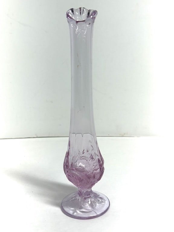 FENTON AMETHYST STRAWBERRY BUD VASE, 1970S: Amethyst glass footed bud vase featuring a raised strawberry and vine motif, produced by the Fenton Art Glass Company. A molded oval maker's mark is present on the underside of the base, signifying pr