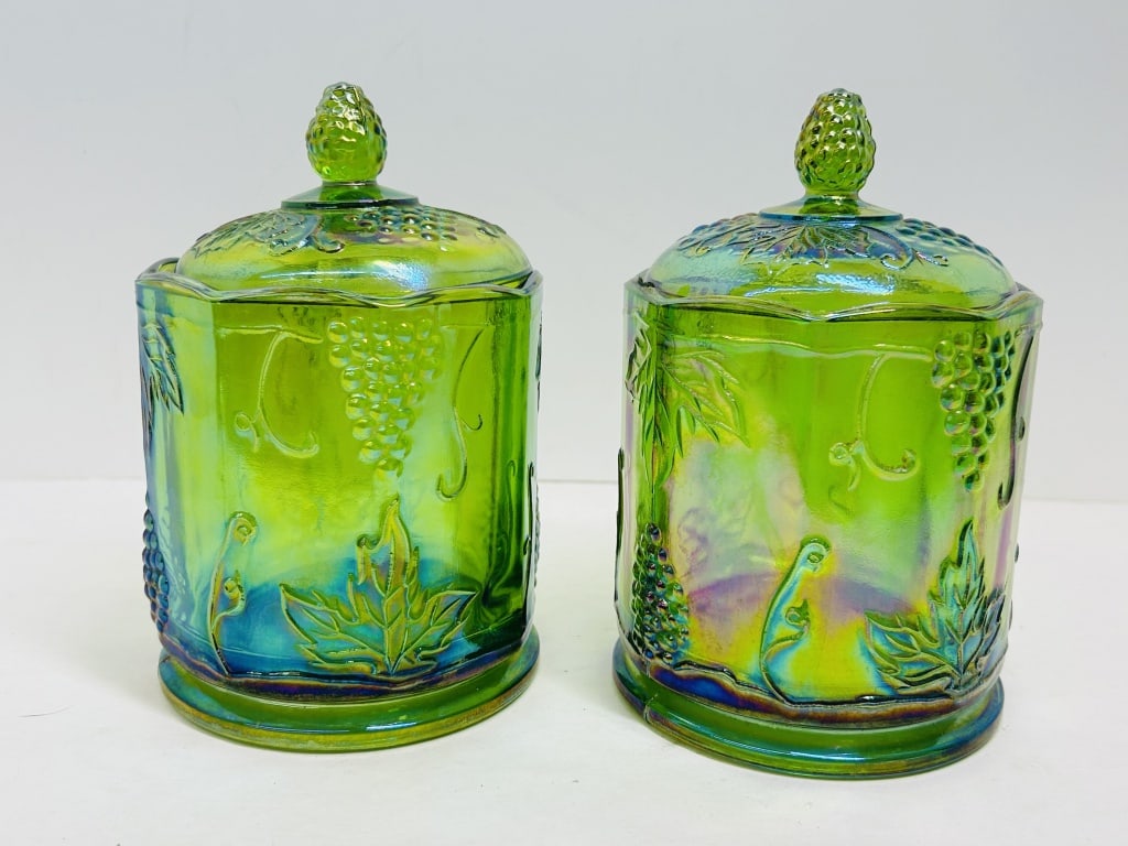 INDIANA GLASS GREEN CARNIVAL CANISTERS, 1970S: A pair of pressed lime green iridescent glass canisters produced by the Indiana Glass Company in the Harvest Grape pattern. The octagonal vessels feature high-relief molded fruit motifs and matching d