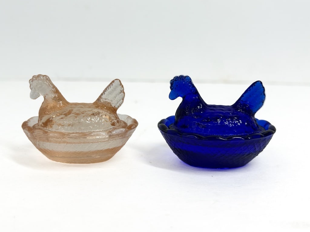 PAIR GLASS HEN ON NEST SALTS: Pair of two-piece pressed glass salt cellars in the Hen on Nest pattern. One example is cobalt blue and the second is peach-colored translucent glass featuring basket-weave textured bases and scallope