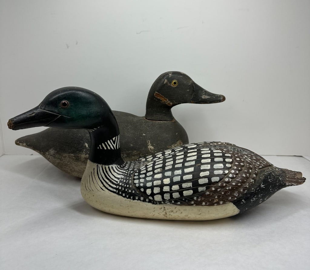 BEIER AND LOON WOODEN DECOYS, 20TH CENTURY: A pair of vintage wooden decoys including a common loon and a working scaup decoy. The scaup features an incised BEIER lead weight and two BB stamps on the underside of the carved body.