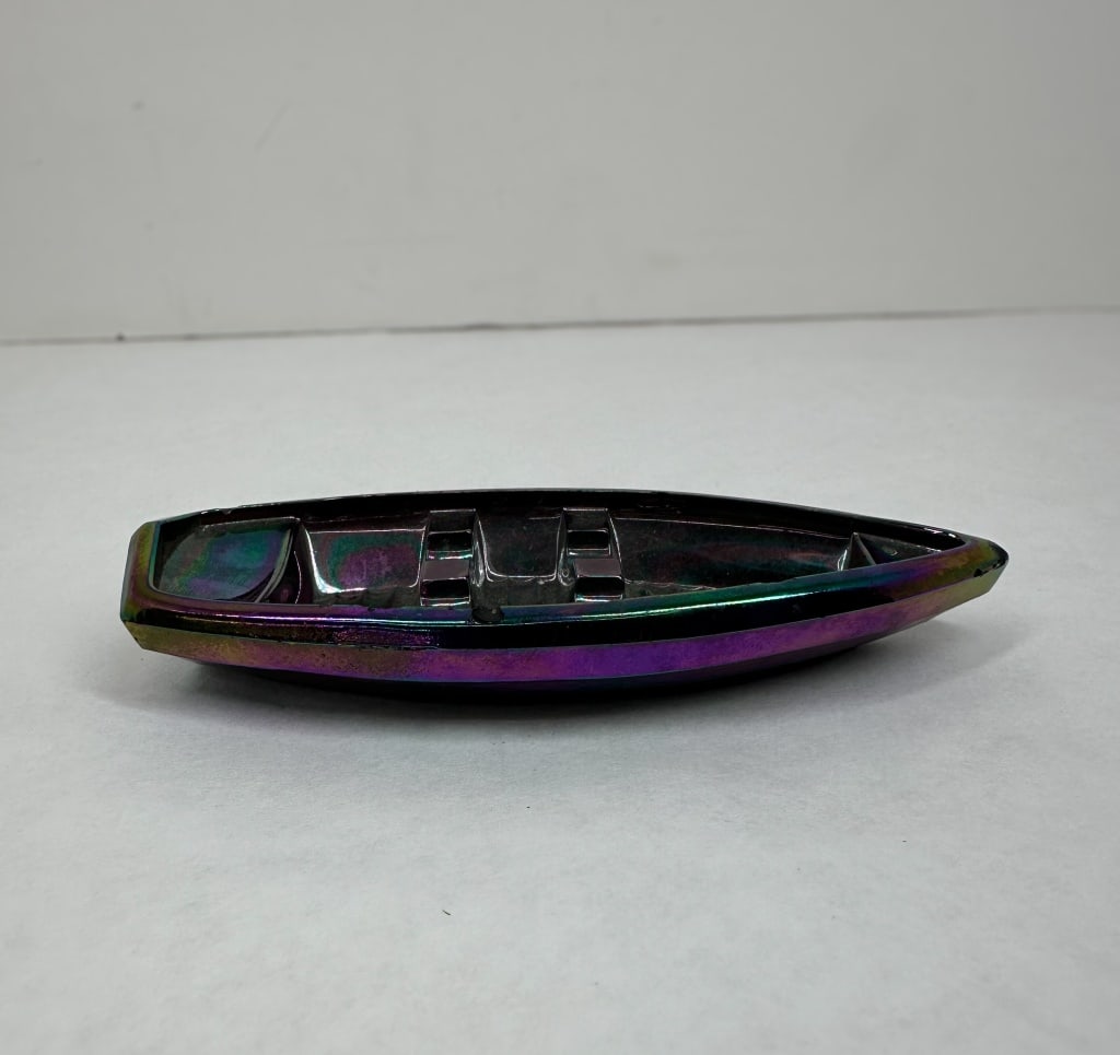FENTON AMETHYST CARNIVAL GLASS SKIFF, 2006: Fenton Art Glass rowboat novelty featuring a heavy multi-color iridescent finish. The vessel includes molded thwarts and oarlock rests.