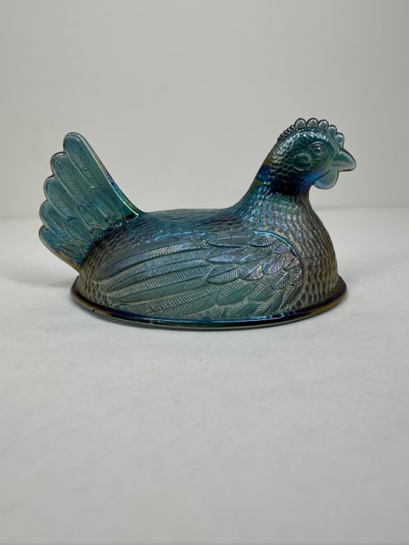 INDIANA GLASS CARNIVAL GLASS HEN LID, CIRCA 1975: Blue iridescent carnival glass hen-on-nest lid produced by the Indiana Glass Company in pattern number 2738. This pressed glass piece features a teal base with a multi-colored iridescent finish and mo