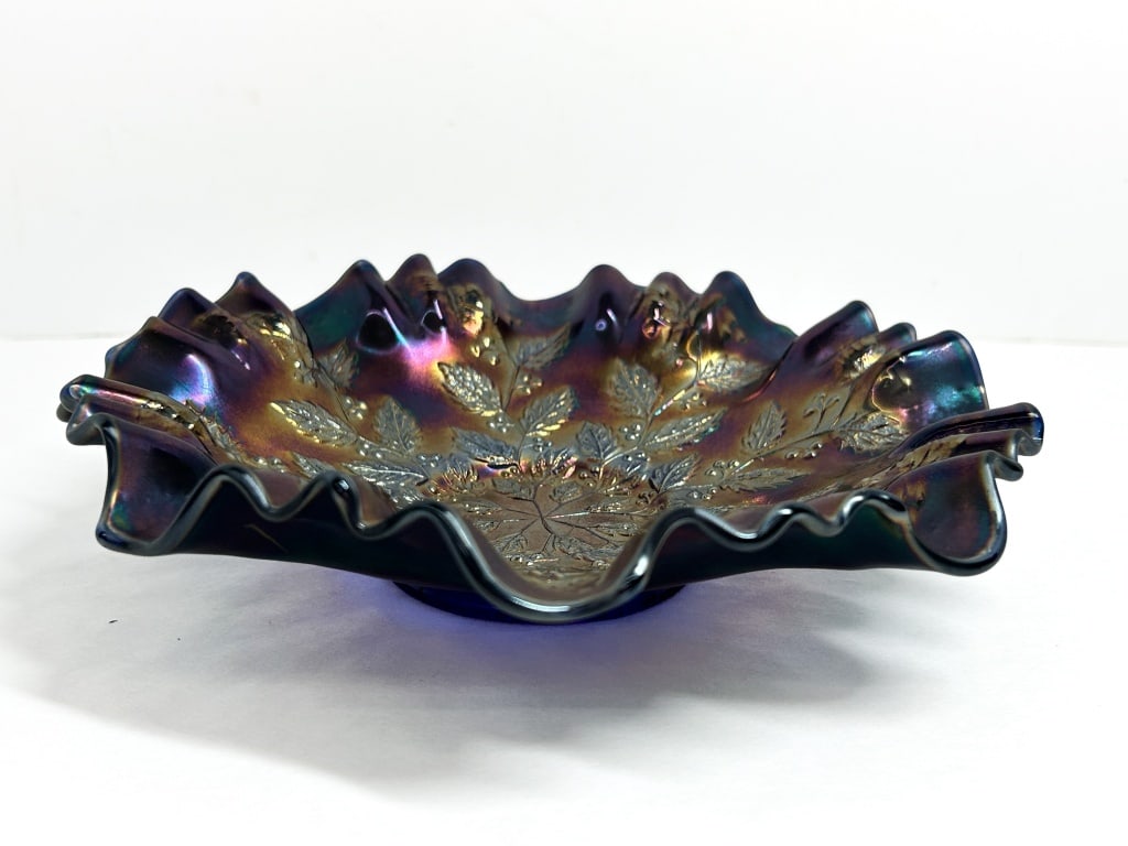 FENTON HOLLY CARNIVAL GLASS BOWL: Fenton Art Glass Company pressed glass bowl in the Holly pattern. The cobalt blue base glass features a ruffled rim and vivid multi-colored iridescent spray finish.