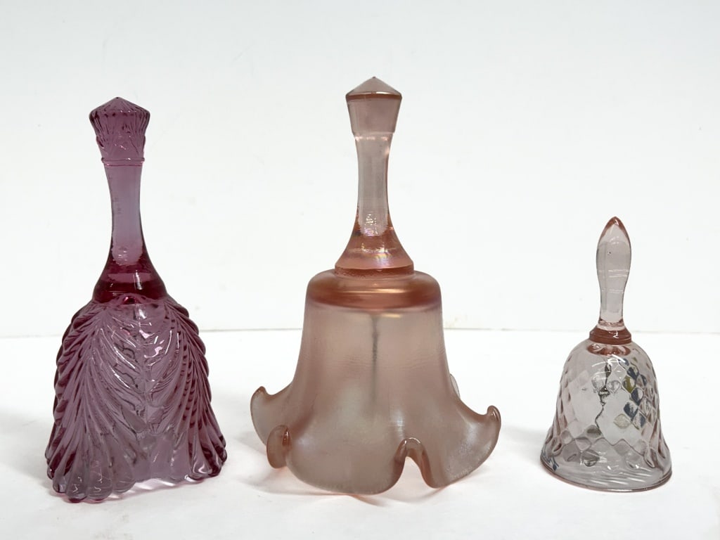 FENTON THREE GLASS BELLS, 20TH CENTURY: Collection of three Fenton glass bells including an amethyst plume pattern bell, a pink satin ruffled bell, and a signed hand-painted diamond quilted bell. The commemorative bell features the script F