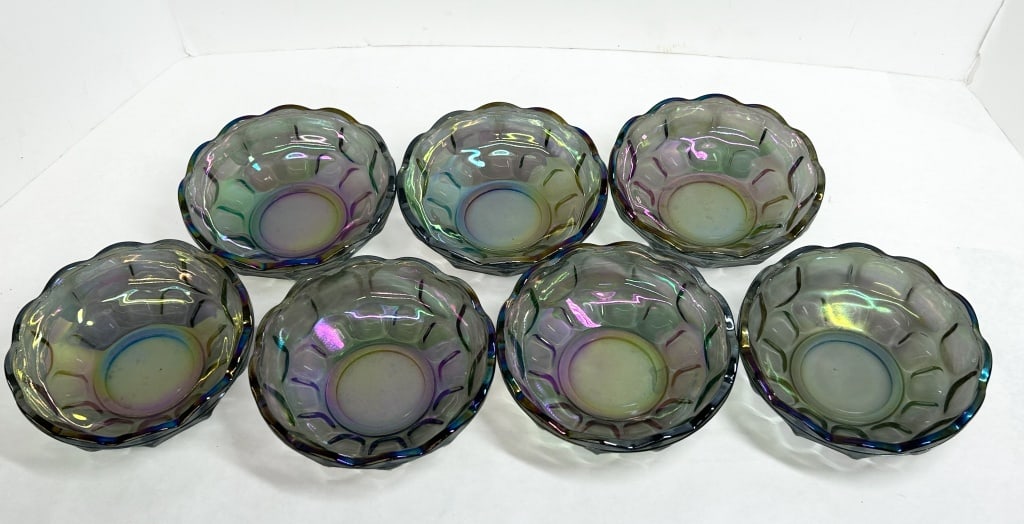 FEDERAL GLASS SEVEN SMOKE CARNIVAL BOWLS, MID-20TH CENTURY: Federal Glass Company Colonial pattern bowls in smoke iridescent glass. This set of seven pressed glass vessels features a repetitive thumbprint motif and scalloped rims.