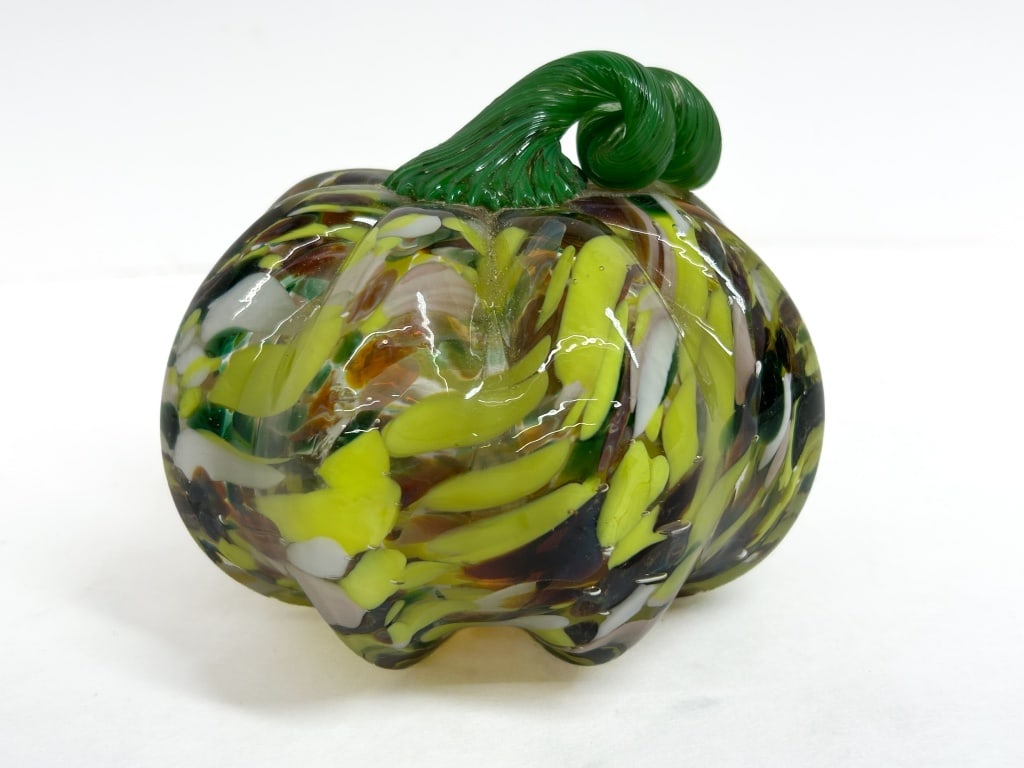 STUDIO GLASS, HAND-BLOWN PUMPKIN, CONTEMPORARY: Hand-blown studio glass decorative pumpkin featuring a clear body with encased yellow, white, and green confetti glass frit. The vessel is finished with an applied, hand-tooled coiled stem in transluc
