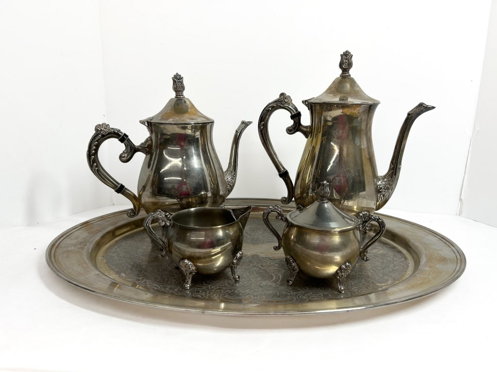 5-PIECE SILVER-PLATED TEA SERVICE, MID-20TH CENTURY: A 5-piece silver-plated tea and coffee service including a coffee pot, teapot, creamer, lidded sugar bowl, and a matching large oval tray. The set is designed in an ornate Victorian revival style with