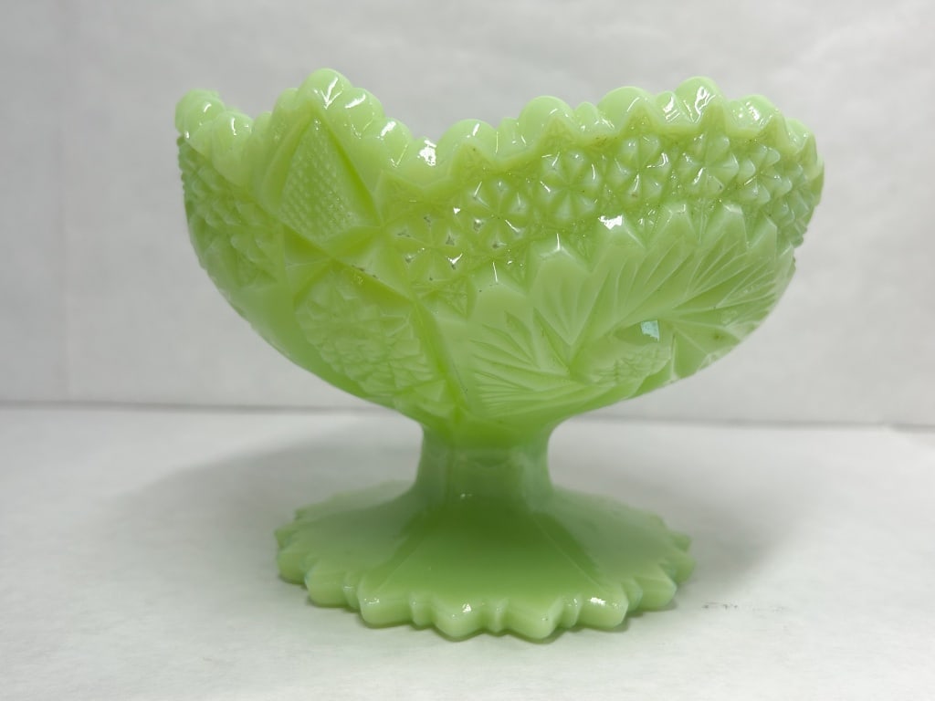 JADEITE FENTON PINWHEEL GLASS PEDESTAL COMPOTE: Opaque jadeite glass pedestal compote featuring a pressed Pinwheel and Star pattern. The piece is finished with a scalloped sawtooth rim and a ribbed pedestal foot, bearing no legible maker marks.