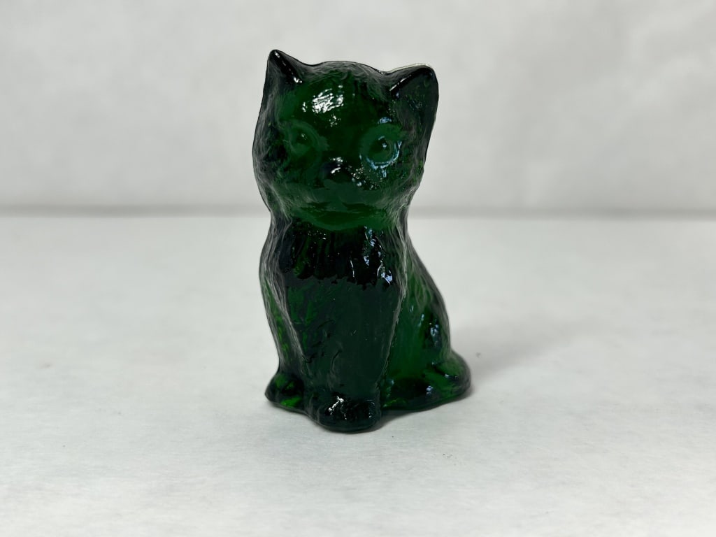 BOYD MISS COTTON EMERALD GREEN GLASS CAT: Seated cat figurine in forest green molded glass produced by Boyd?s Crystal Art Glass. An impressed diamond mark containing a capital B, flanked by the numerals 1 and 6 on the lower rear, identifies t
