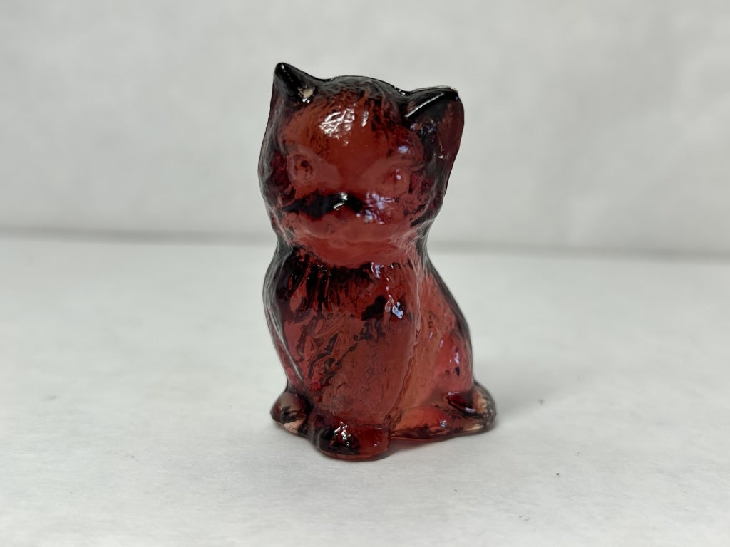 BOYD TRANSLUCENT RED MISS COTTON KITTY: The lower reverse portion bears an embossed mark consisting of a capital letter I and G flanking a central diamond containing the letter B.