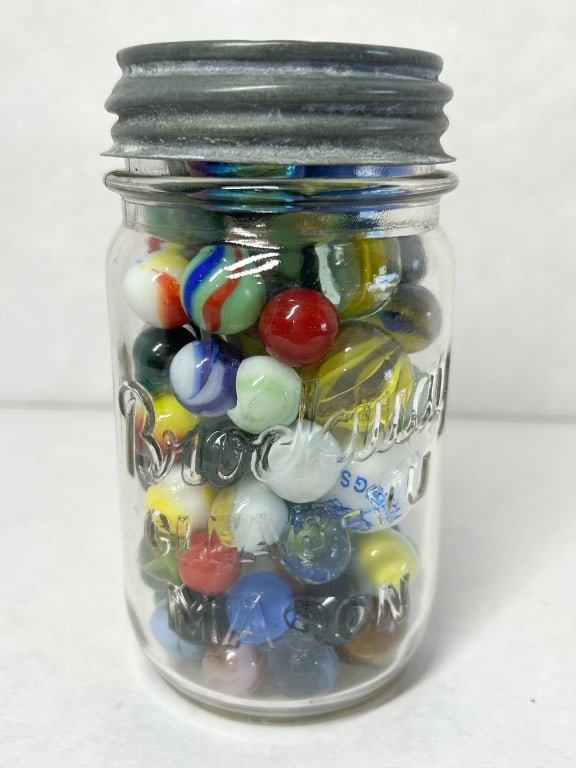BROCKWAY GLASS JAR OF VINTAGE MARBLES: Brockway Special Mason jar containing an assortment of vintage glass marbles in various sizes and colors. The collection includes a promotional Lakewood Vikings marble bearing a blue printed logo and 
