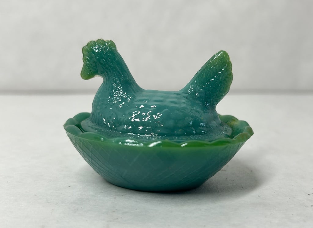 GREEN SHADES GLASS HEN ON NEST: Miniature green slag glass hen on nest. The two-piece covered dish features a marbled malachite color pattern with a basketweave molded base and feathered lid; no maker marks or labels are visible.