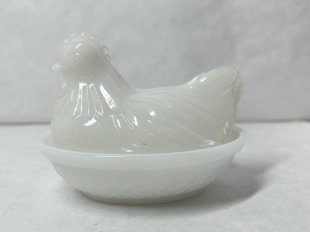 HAZEL ATLAS WHITE MILK GLASS HEN ON NEST: A two-piece covered dish in opaque white milk glass featuring a nesting hen lid and basketweave base. This small individual-sized vessel displays detailed molded feathering and a smooth interior rim.