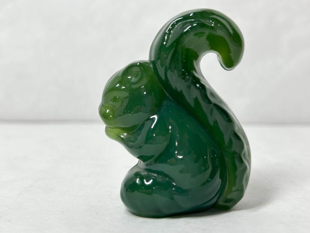 BOYD JADENE SAMMY THE SQUIRREL: Stylized squirrel figurine crafted in dark green opaque Jadene glass with a high-gloss finish. An oval paper label on the base is inscribed JADENE and H-14 in blue ink.