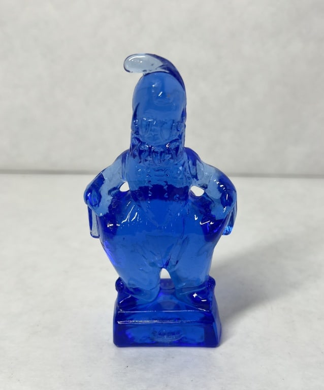 MOSSER MINDY CLOWN COBALT BLUE: Mosser Glass figurine in pressed cobalt blue glass depicting a bearded character with hands on hips. The front of the rectangular plinth is impressed with the letters YOU, and the reverse features an 