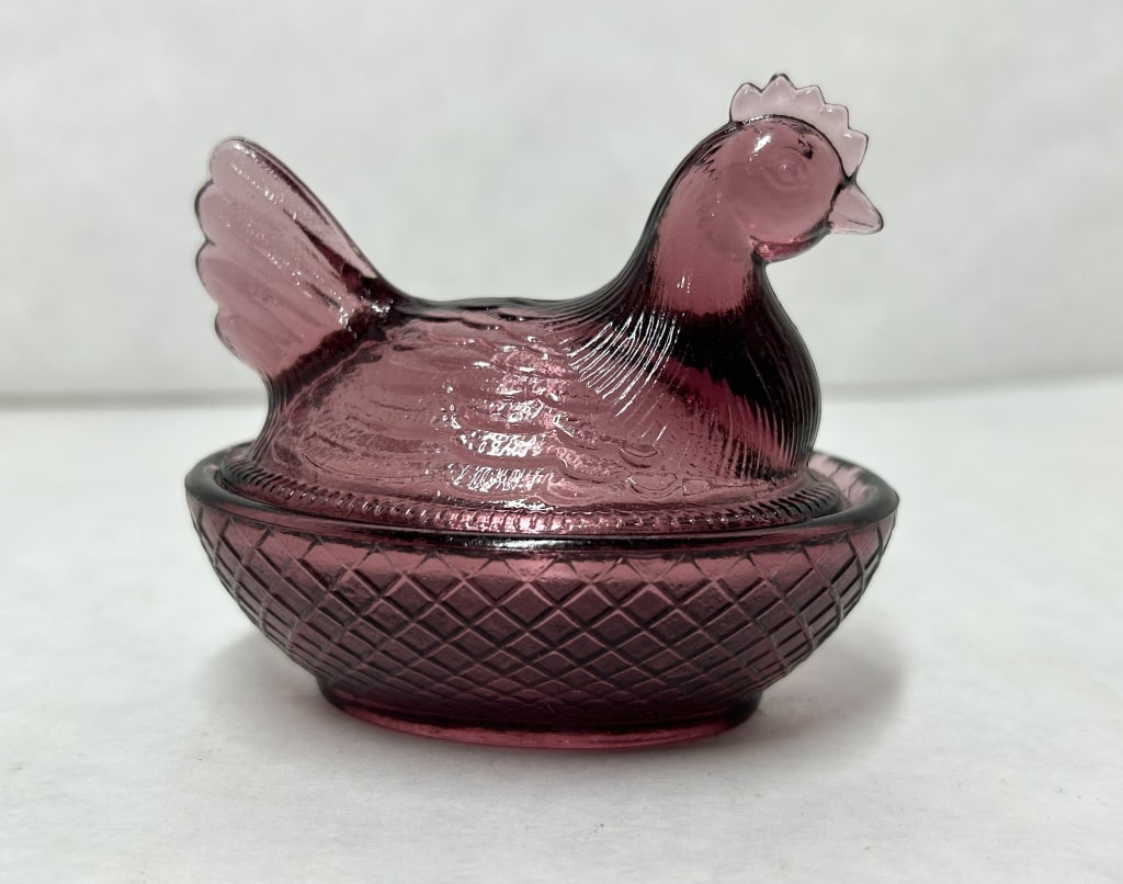 *BOYD AMETHYST GLASS HEN, 1990S: Amethyst pressed glass miniature covered dish in the hen on nest form produced by Boyd's Crystal Art Glass. The interior base features a molded mark with the word BOYD in script beneath a letter B wit