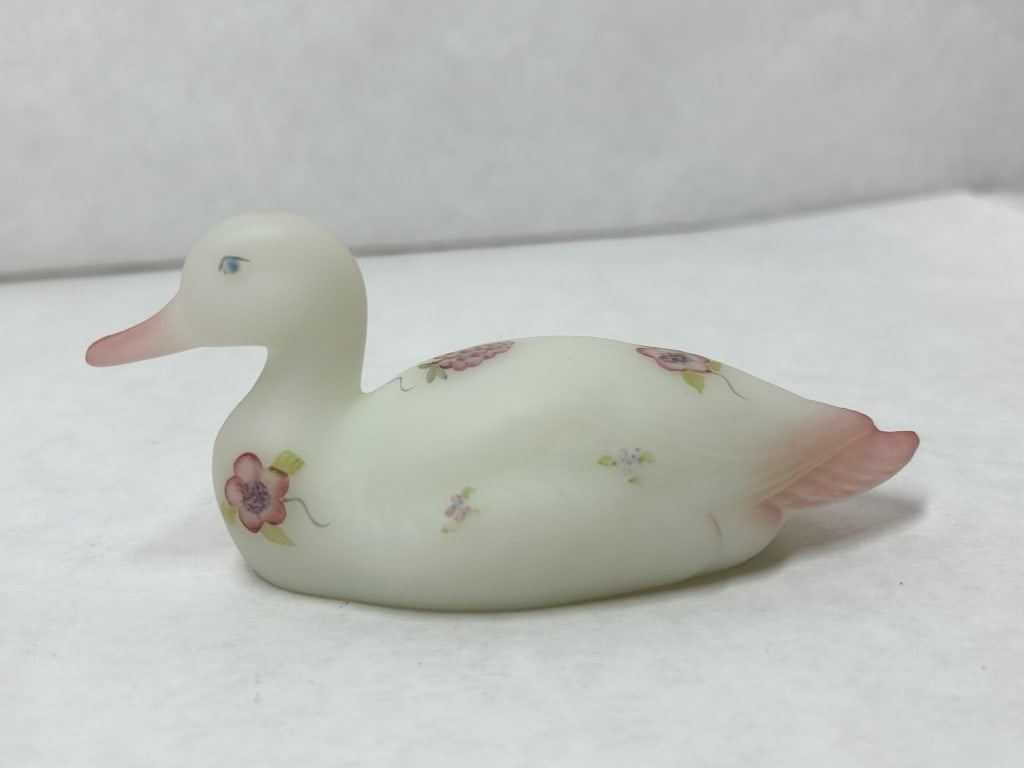 FENTON SATIN GLASS DUCK, 20TH CENTURY: A Fenton Art Glass Company duck figurine in white frosted satin glass with hand-painted floral decoration and pink blushing. The underside bears a painted signature reading Hand Painted by S. Stevens 