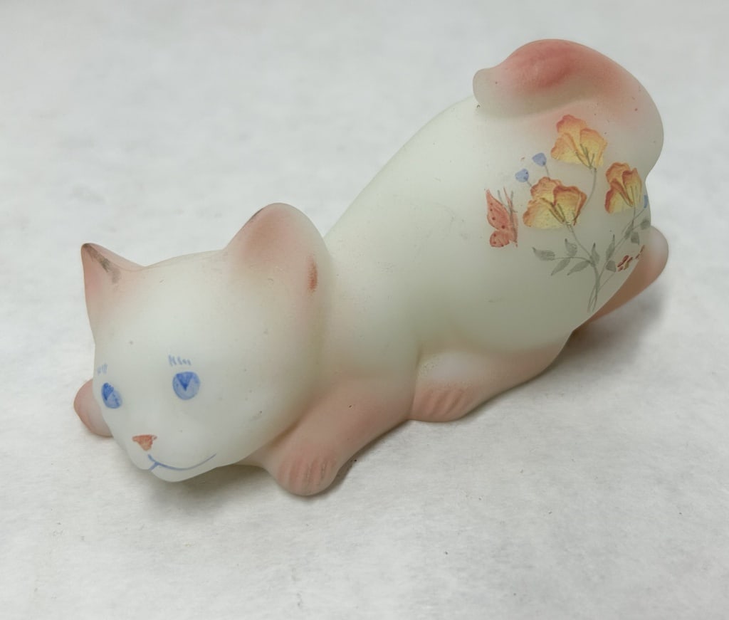 BURMESE SATIN GLASS POUNCING KITTEN: A vintage pouncing kitten figurine crafted from Burmese frosted satin glass. The piece is hand-decorated with a floral motif including orange flowers and a butterfly. No maker marks are visible on the