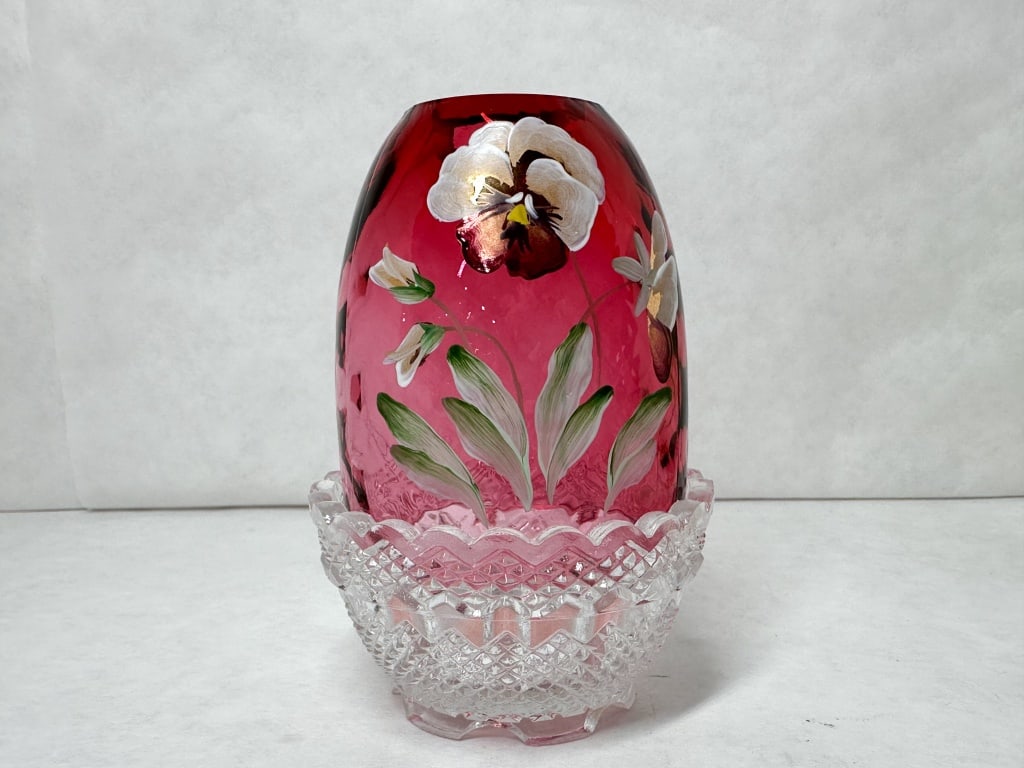 D. CUTSHAW PAINTED RUBY FAIRY LAMP: Ruby glass fairy lamp featuring a pansy floral motif hand-painted by artist Donna Cutshaw. The shade interior rim is signed in white cursive script reading handpainted by D. Cutshaw and the piece rest