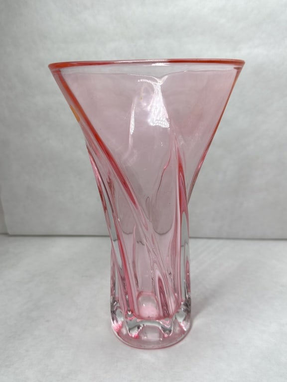 MCM TWISTED PINK ART GLASS VASE: A hand-blown trumpet-form art glass vase featuring a twisted optic rib design. The vessel is constructed with transparent pink glass encased in clear glass, tapering to a weighted base and finished wi