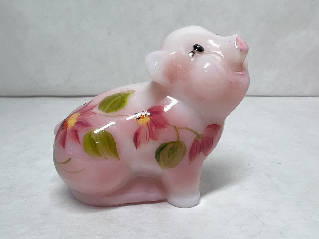 FENTON ROSALENE GLASS PIG FIGURINE: A Fenton Art Glass pig figurine in Rosalene glass featuring a hand-painted floral motif and a satin finish. The base bears a molded script letter F in an oval and a hand-painted signature in gold-tone