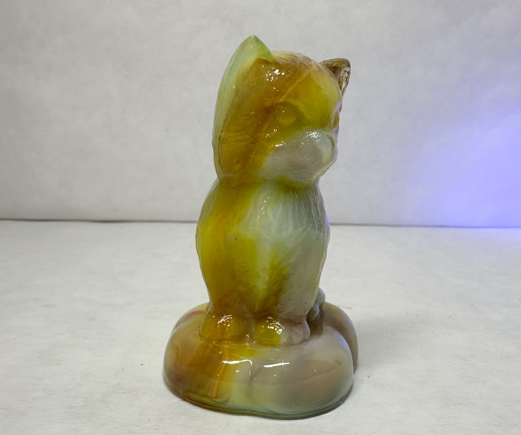 BOYD SITTING KITTEN ON PILLOW SLAG GLASS CAT, VINTAGE: Seated cat figurine in marbled amber and white slag glass produced by Boyd Crystal Art Glass. The figure bears an embossed diamond mark containing the letter B and exhibits orange-pink cadmium fluores